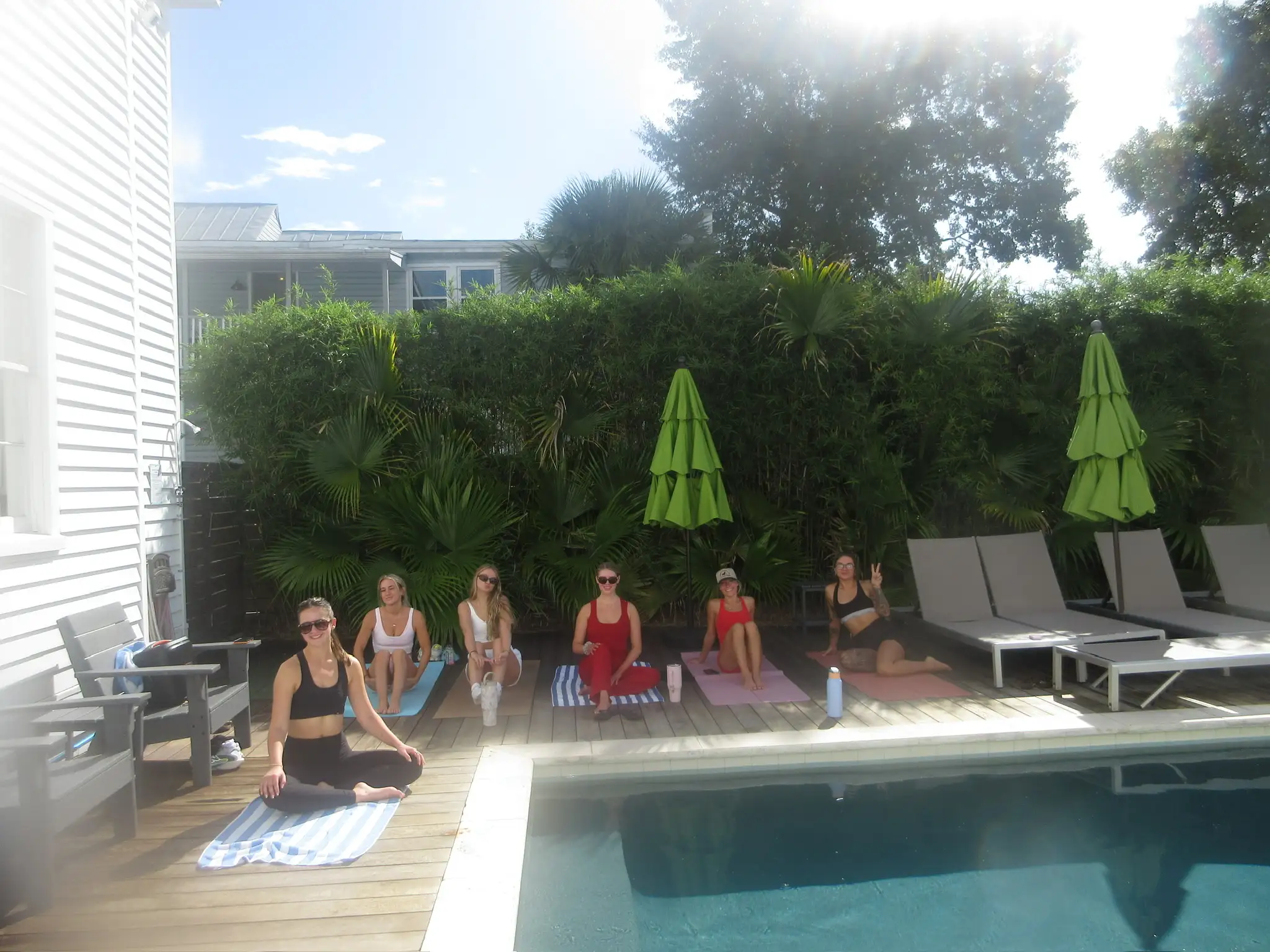 Michaela leading a poolside yoga session for a bachelorette party