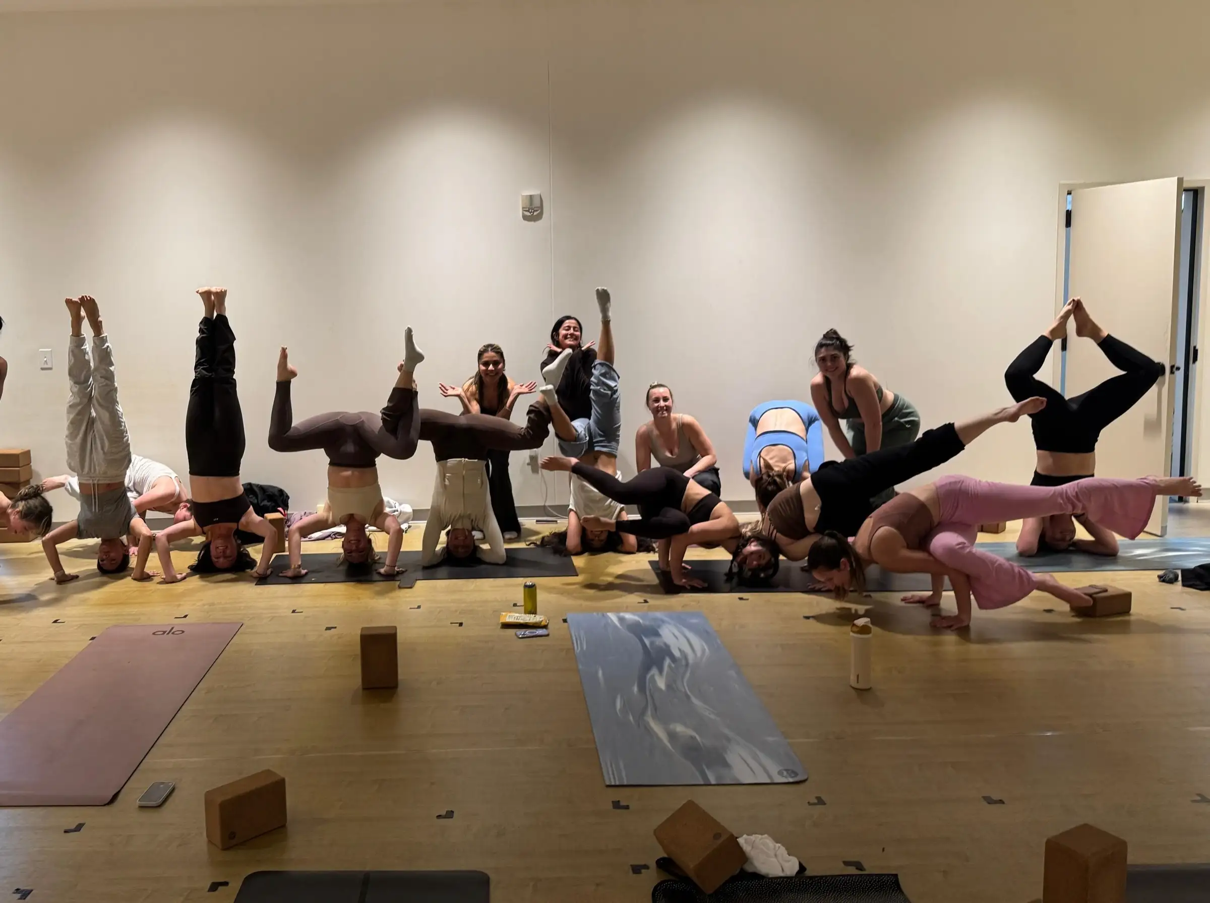 A studio inversion workshop, students in headstands and arm balances